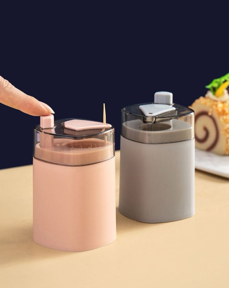 Pop-up toothpick dispenser presenting a single toothpick